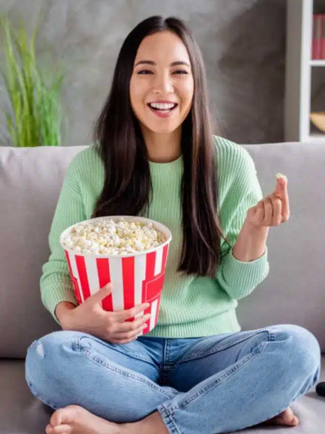 Woman eating popcorn and watching tv