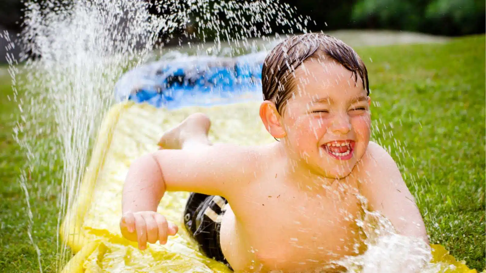 Child playing in garden hose water