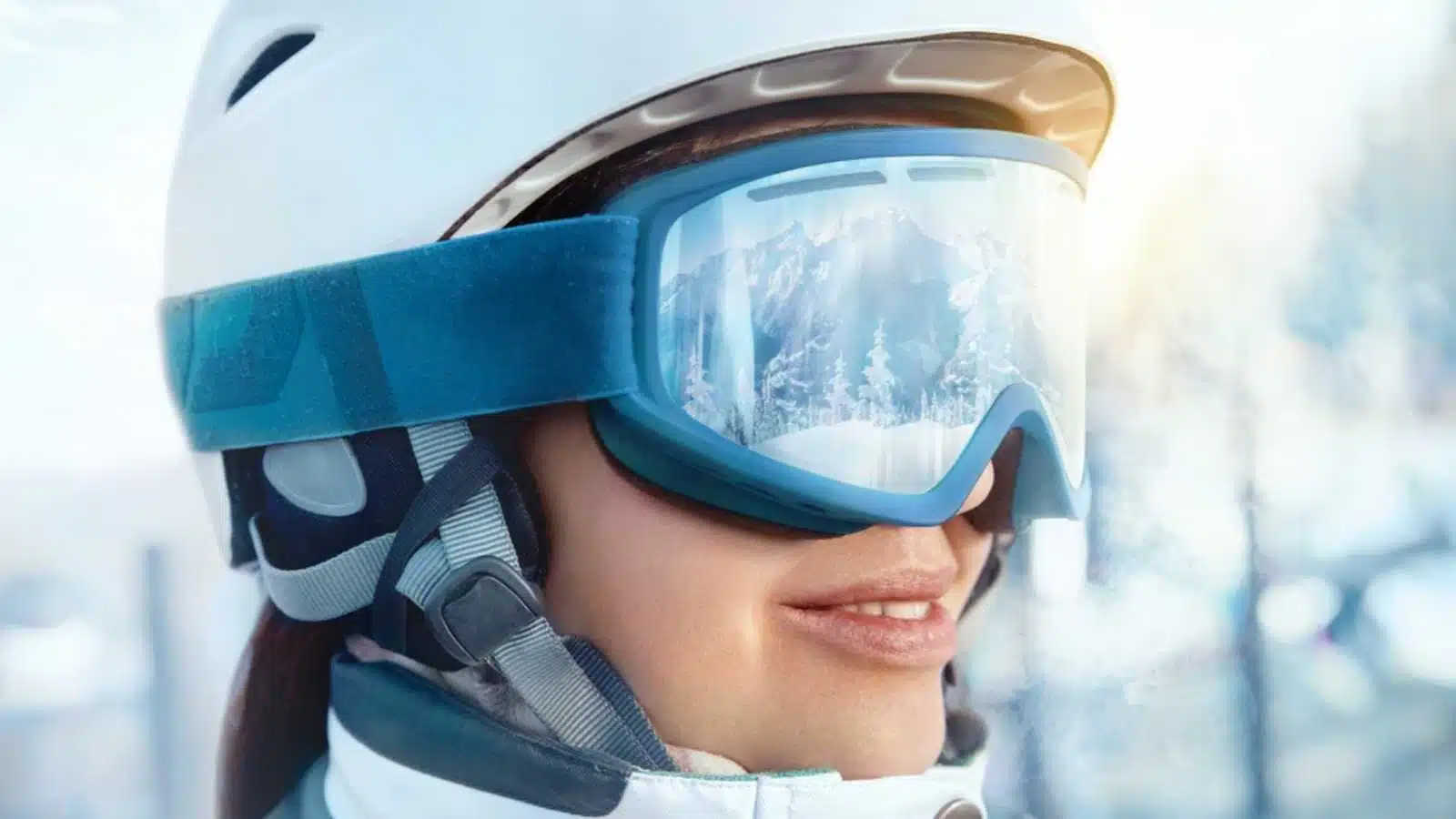 Close Up Of The Ski Goggles Of A Woman With The Reflection Of Snowed Mountains. Portrait Of Woman At The Ski Resort On The Background Of Mountains And Sky.