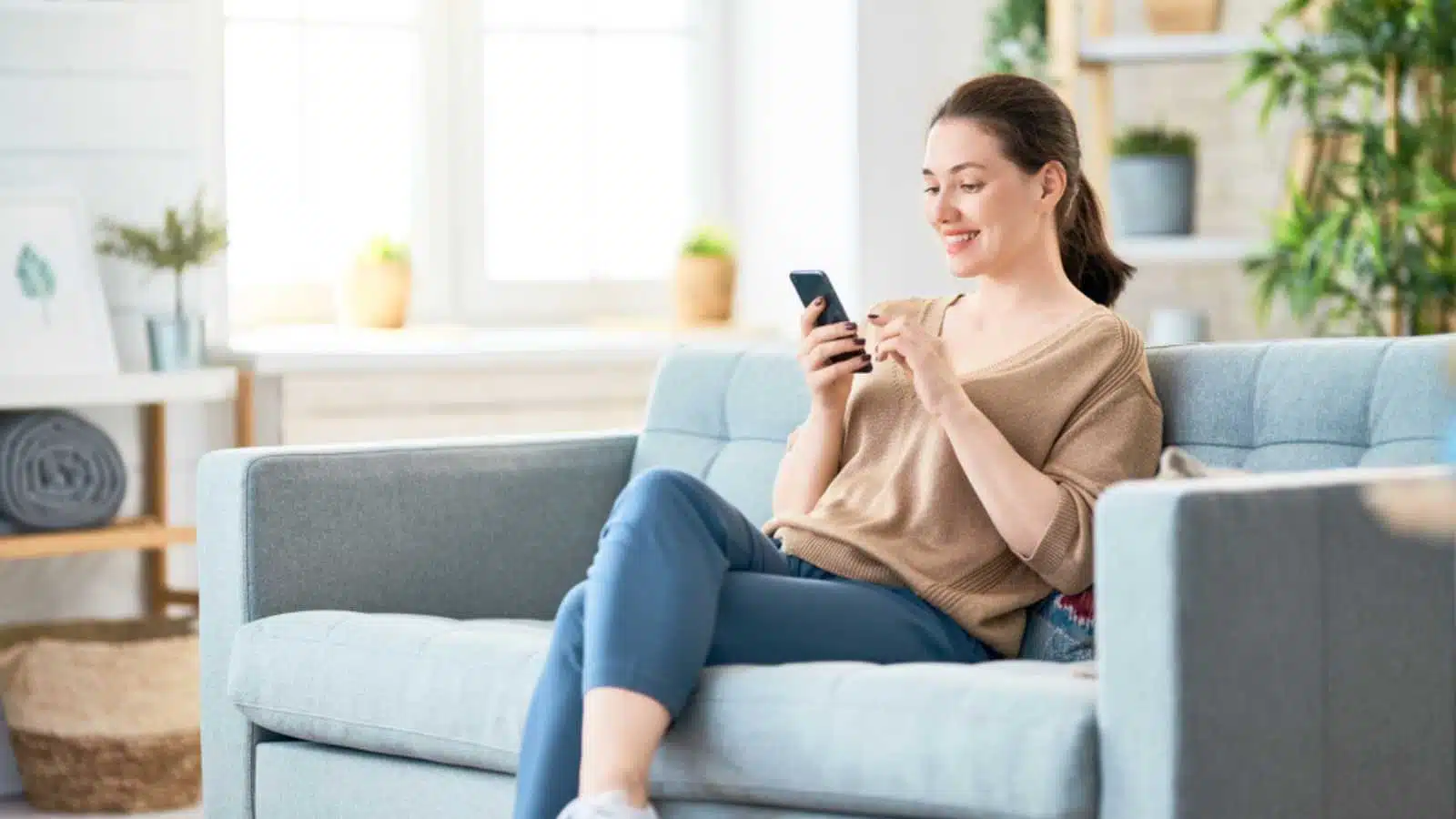 Woman with mobile in sofa