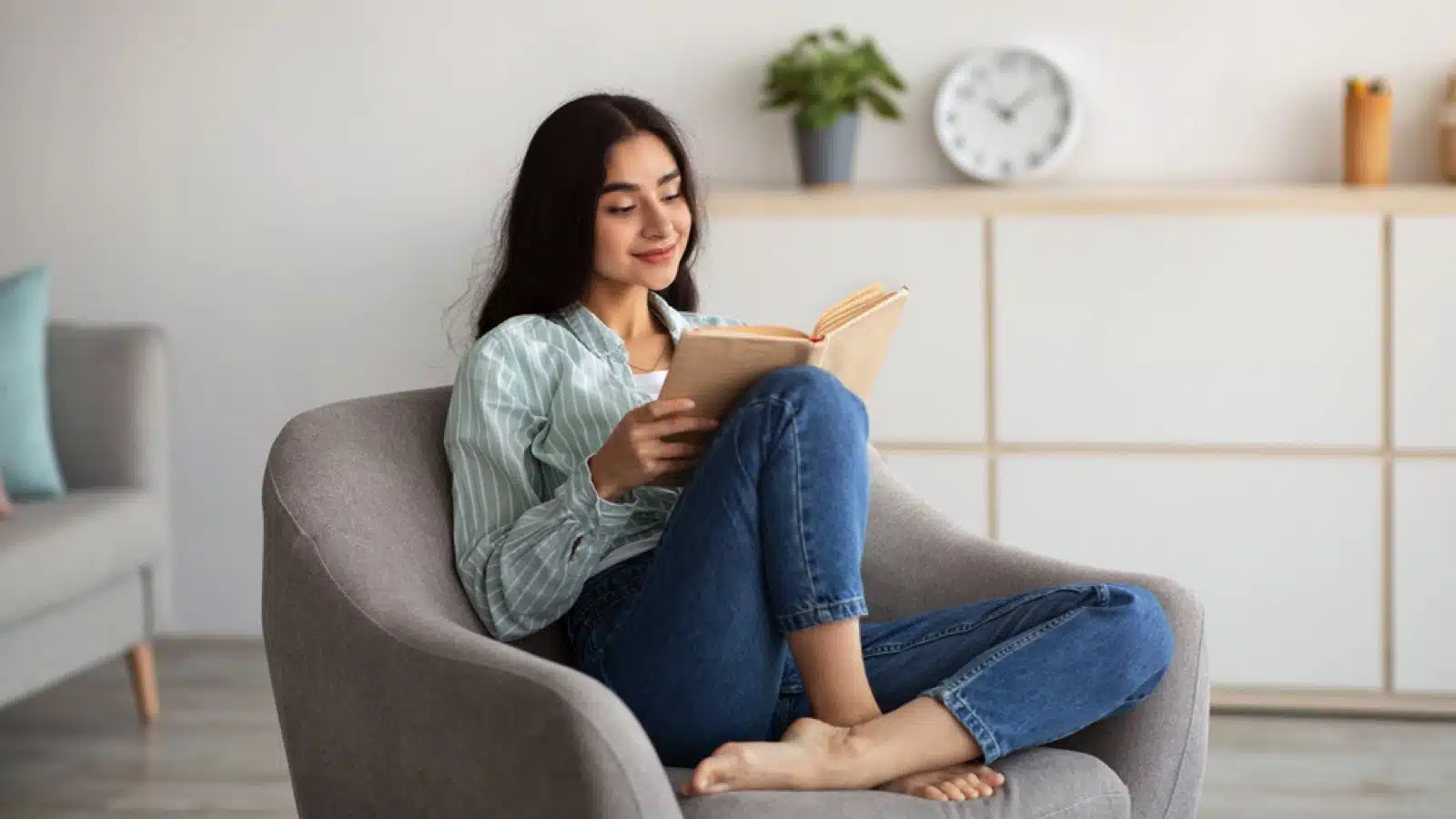 Woman siting in sofa reading book