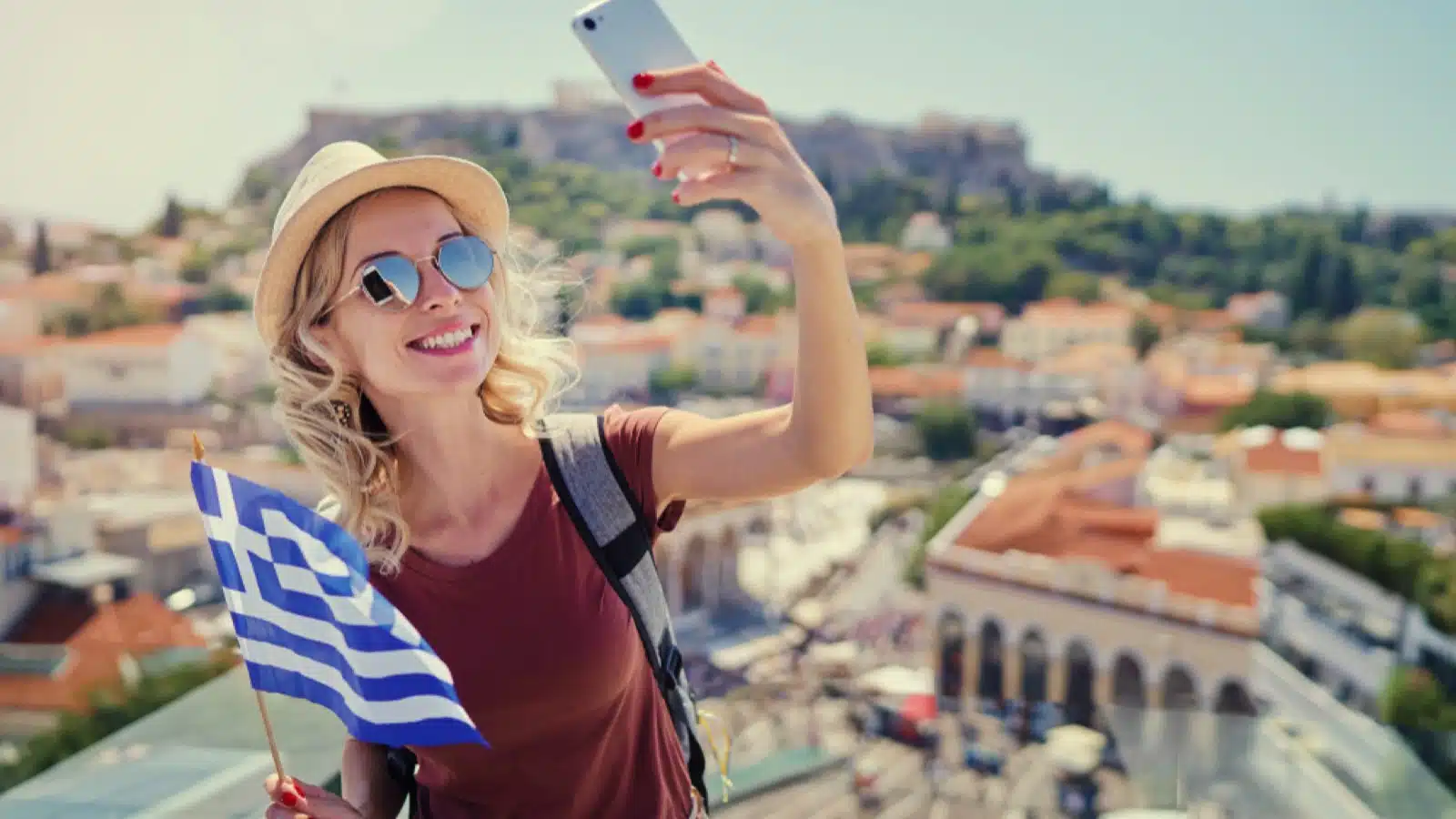 Young traveling woman with national greek flag