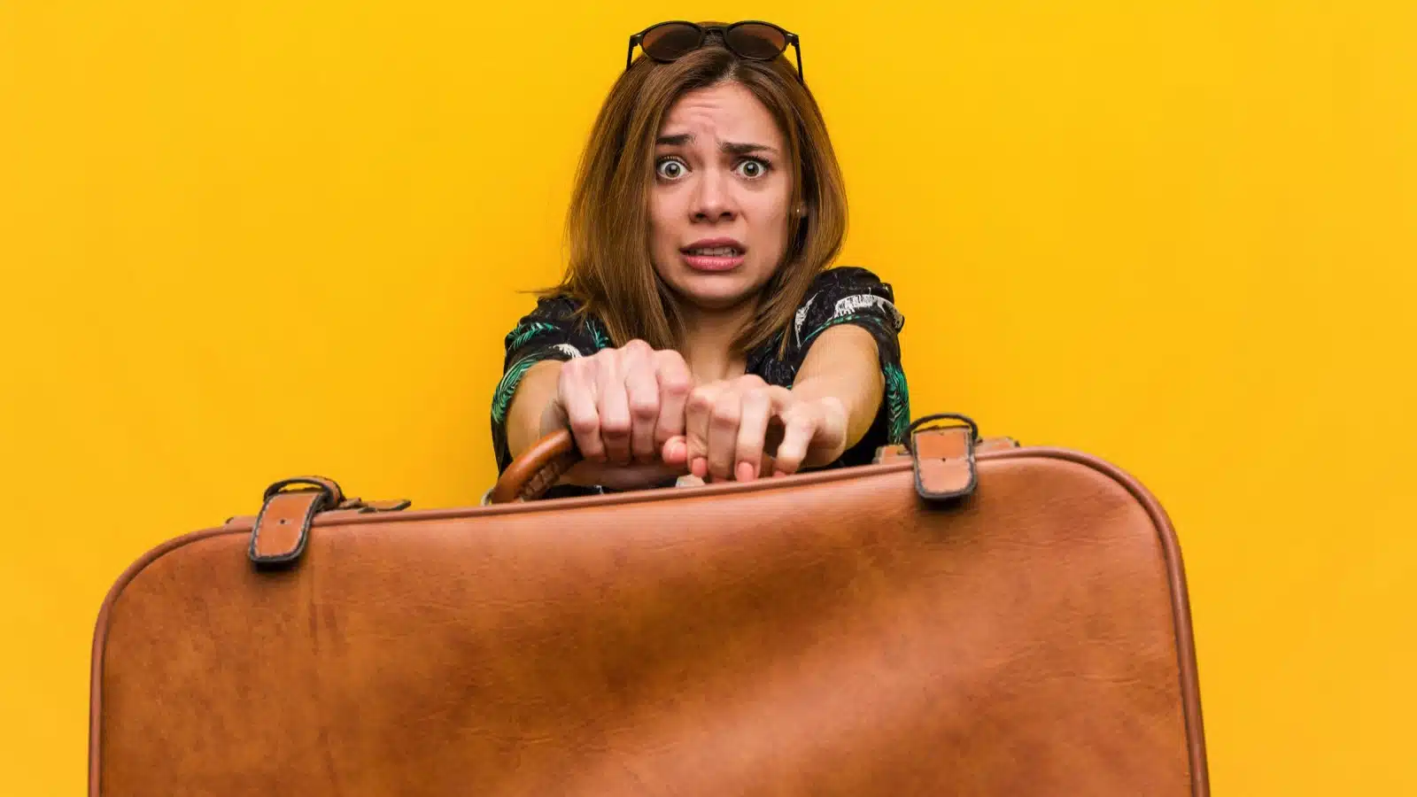 Traveler woman holding leather bag scared