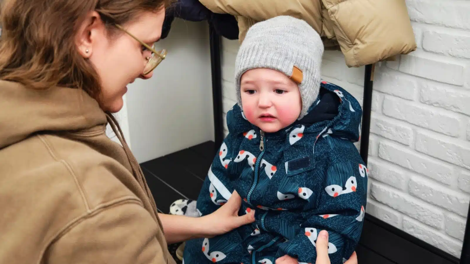 Woman dressing baby for cold weather